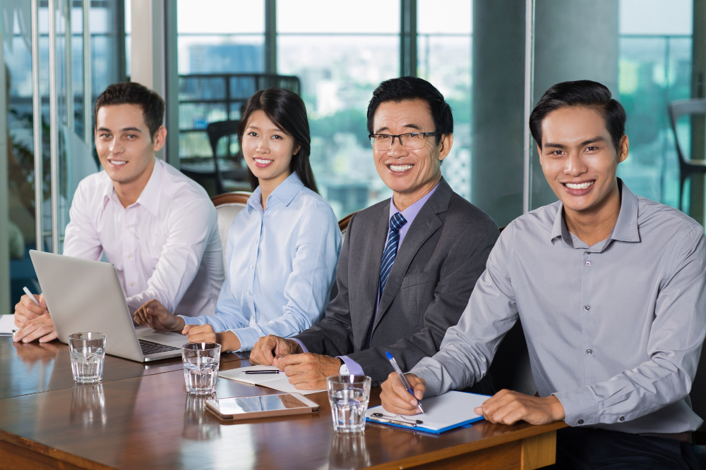 A team of four consultants seated at a boardroom table