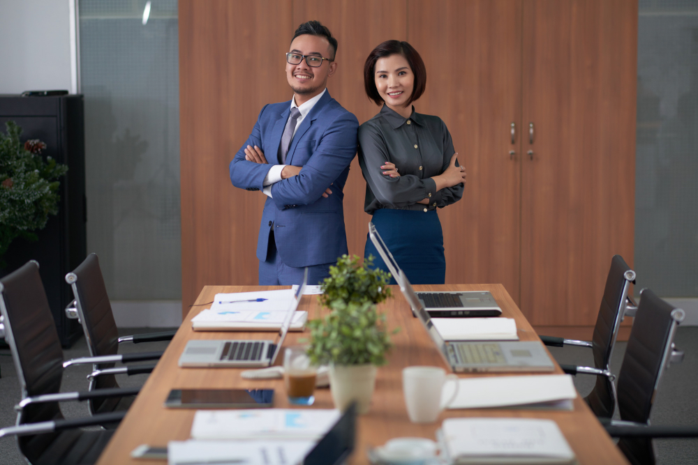 Two finance professionals standing confidently in a boardroom