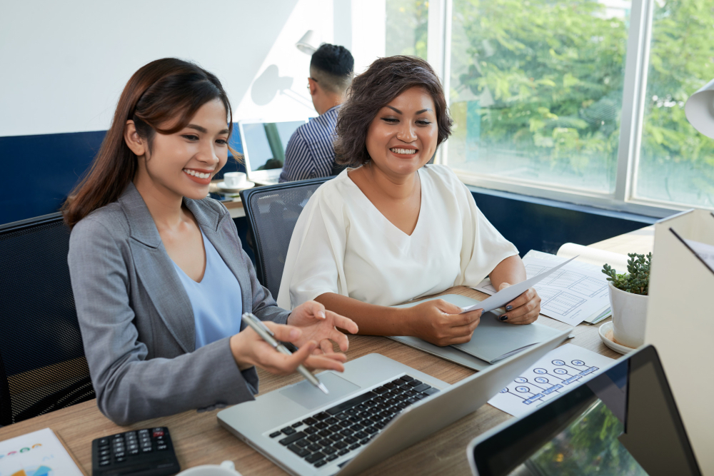 Two accountants reviewing financial workflows on a laptop